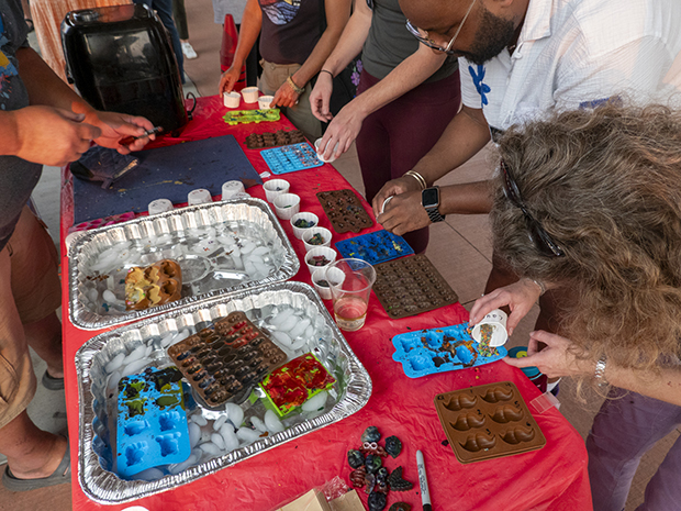 A group of people pouring melted crayons into molds